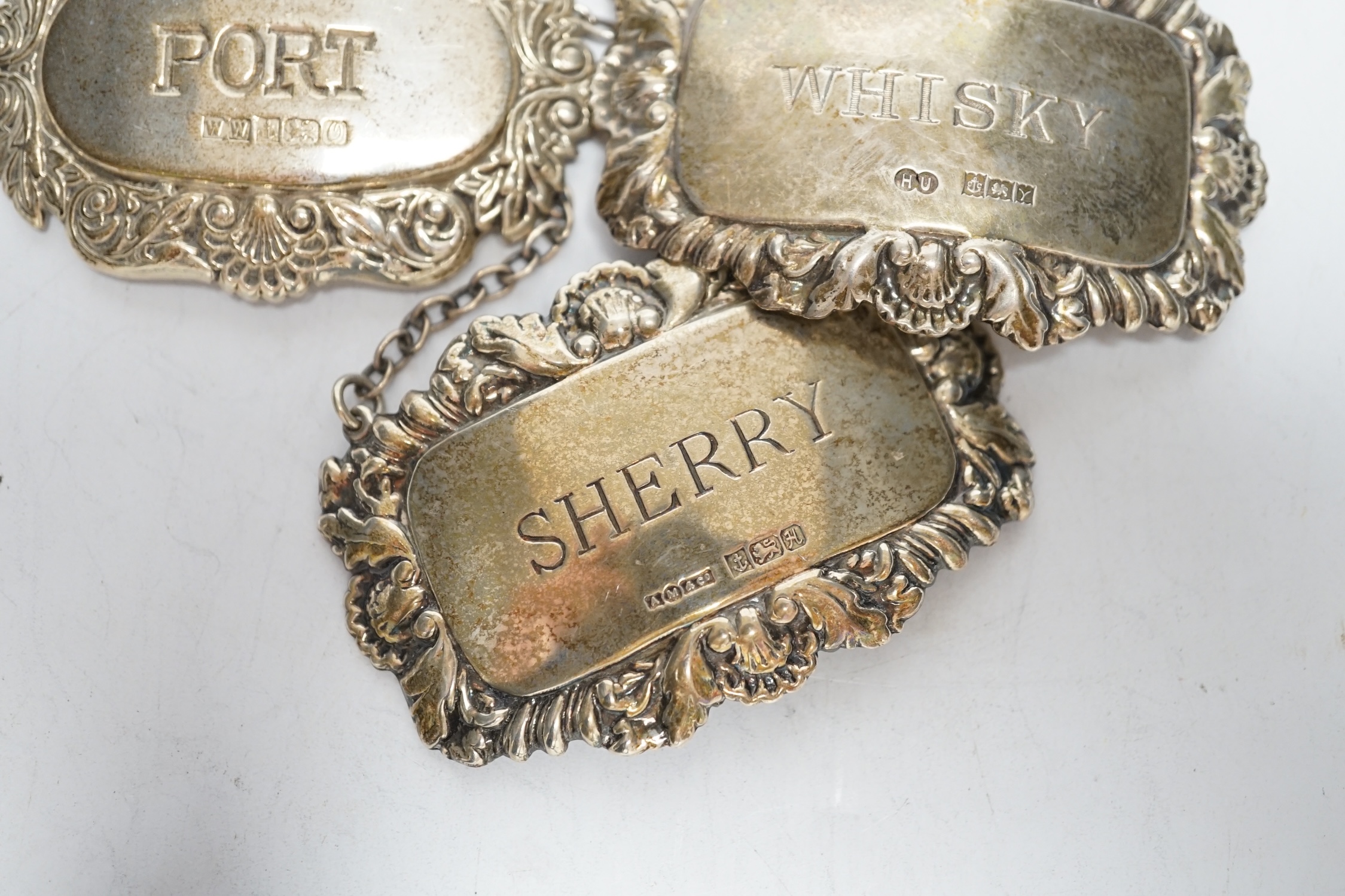 Three assorted modern silver wine labels.